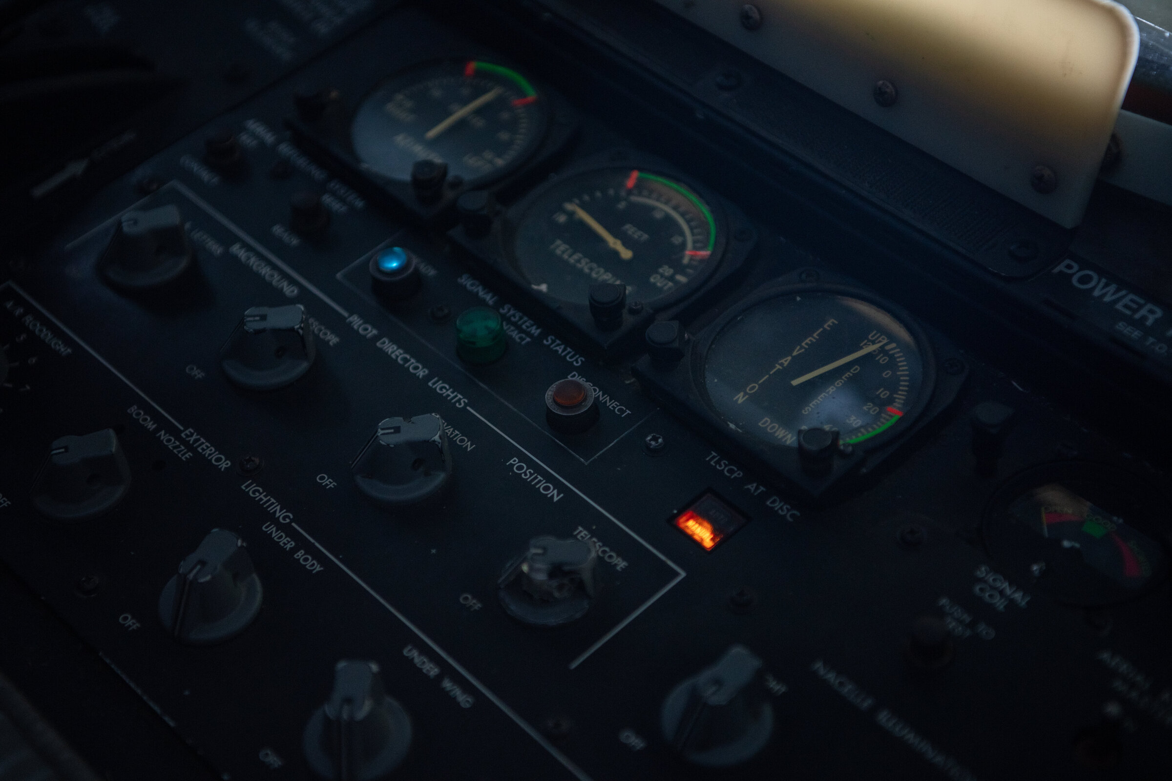 Aerial refueling control panel with analog elevation and telescope gauges, labeled rotary switches, and illuminated ready and manual indicator lights.