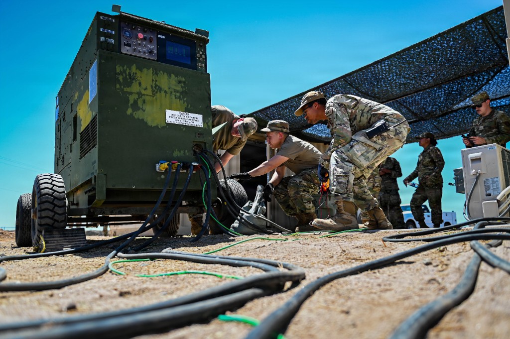 Service members maintaining field power equipment at a military installation